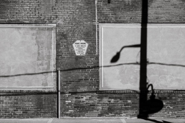The sharp sunlight brings out the wall's texture, but it also creates graphic shadows of nearby objects along its surface. Image: Shalan and Paul
