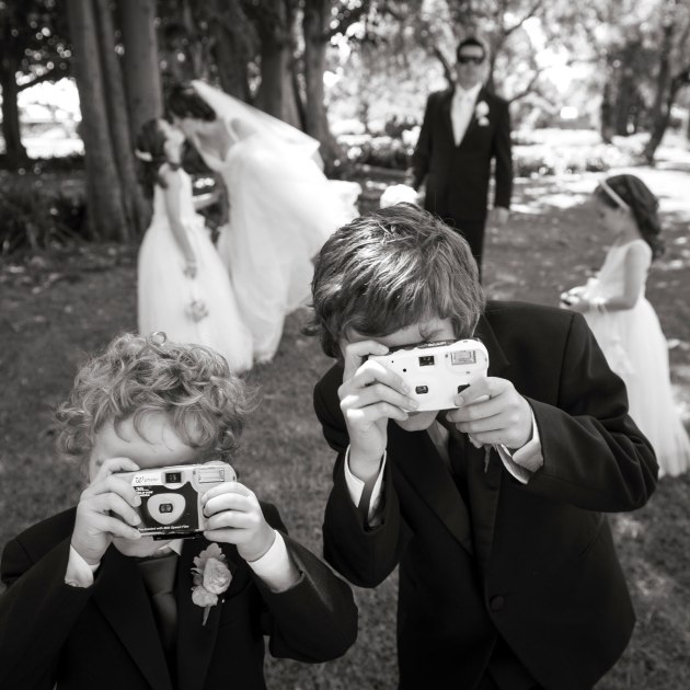 I can’t remember if this photo was set up or not, but noticing the two young page boys had disposable cameras, I probably asked them to make a photo of me making a photo of them.